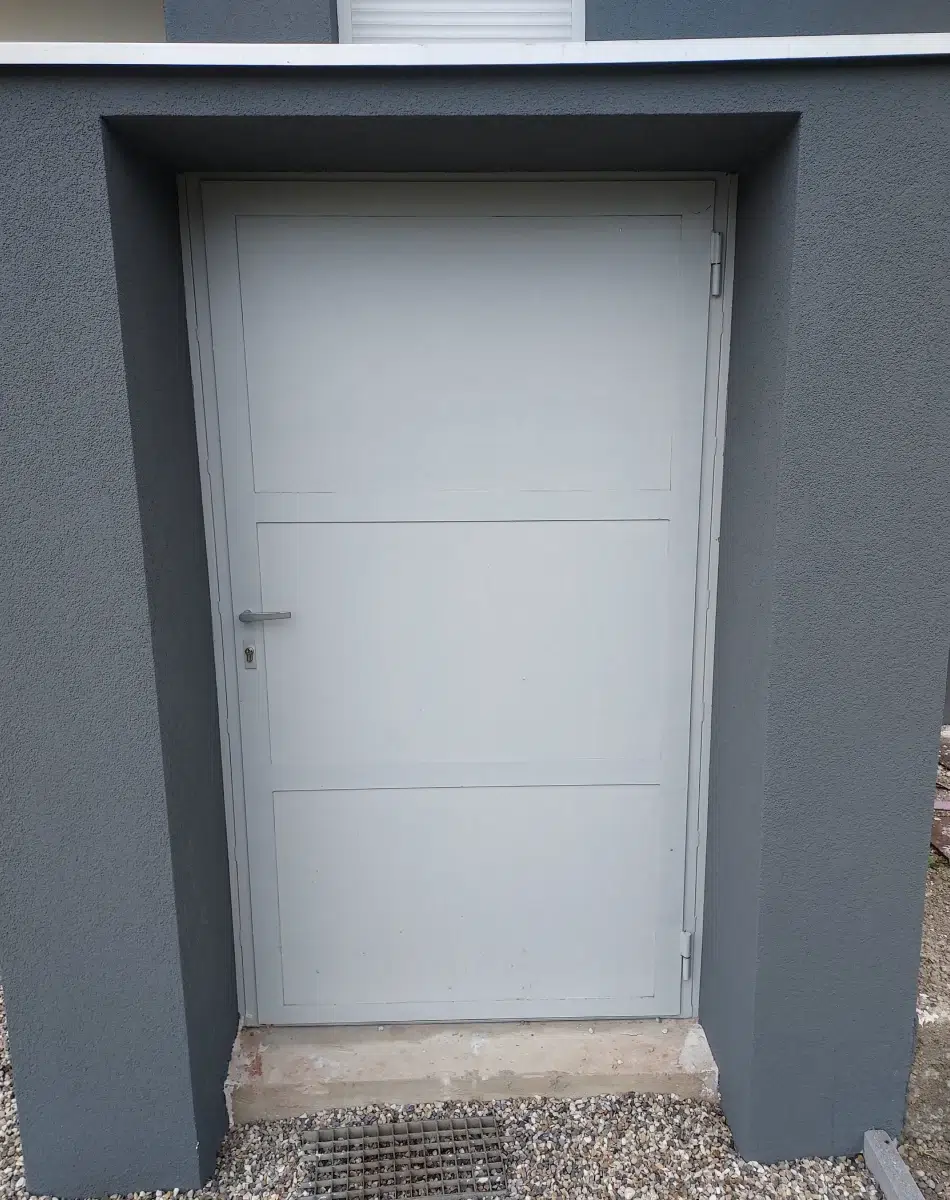 Porte blanche encadrée de murs gris
